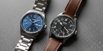 two swiss watches on gray concrete surface one with polished 20260331 133107